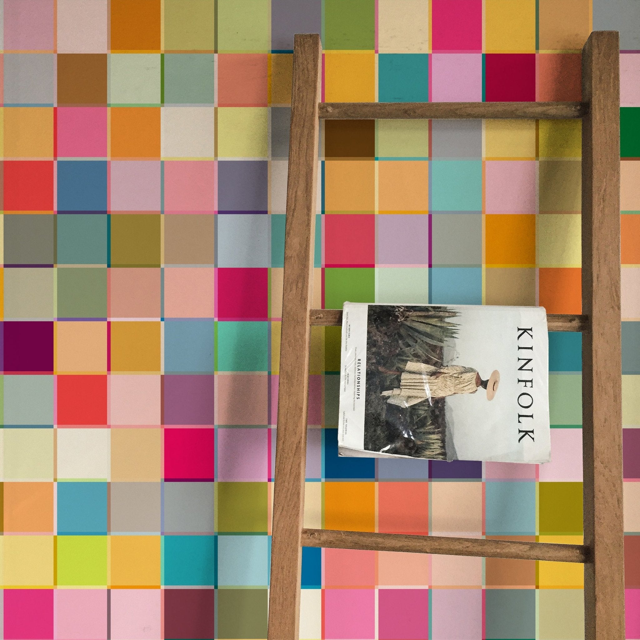 razzle dazzle multicolored checkered wallpaper on a wall behind a decorative wooden ladder