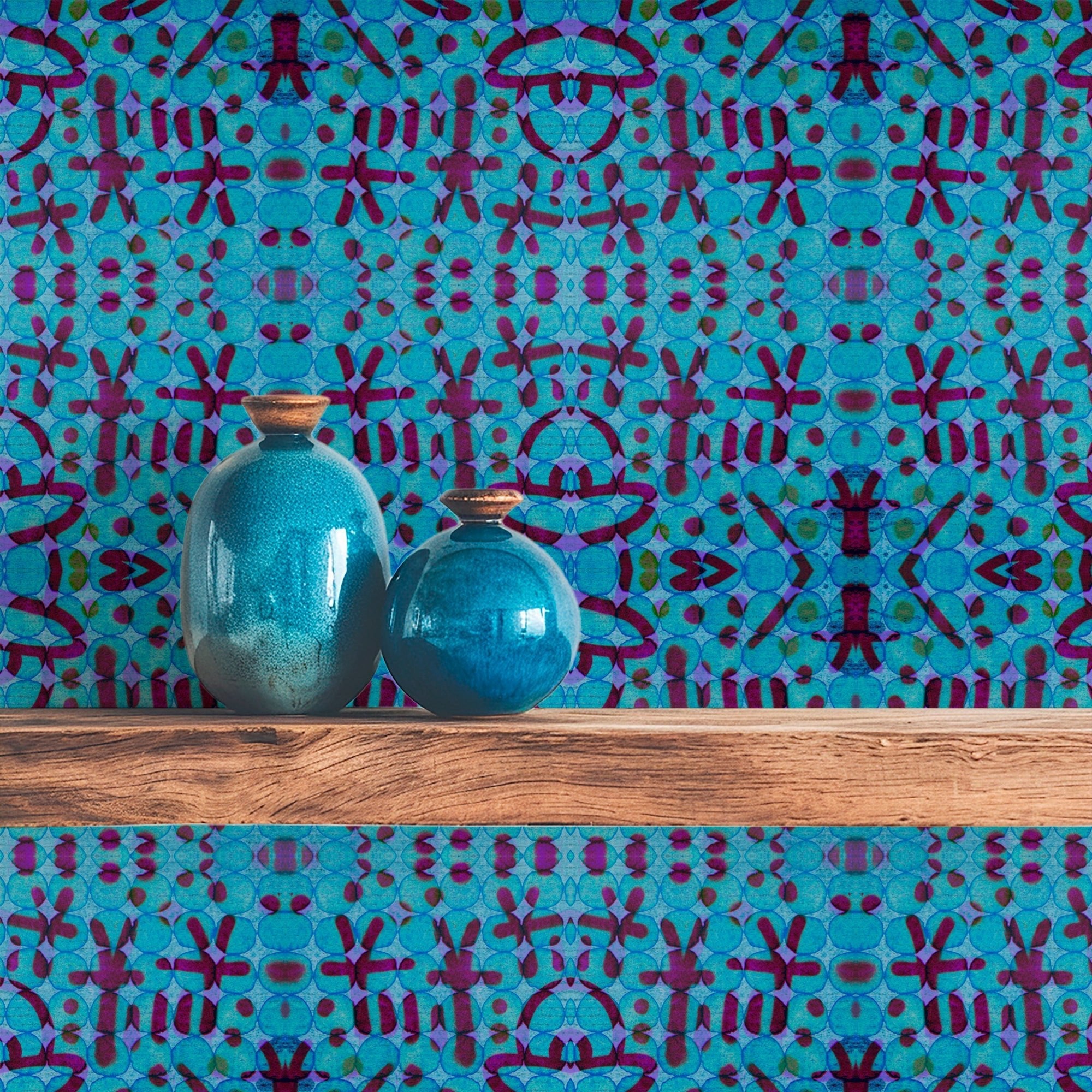 Shibori wallpaper in blue and turquoise tones shown on a wall behind a wooden shelf.