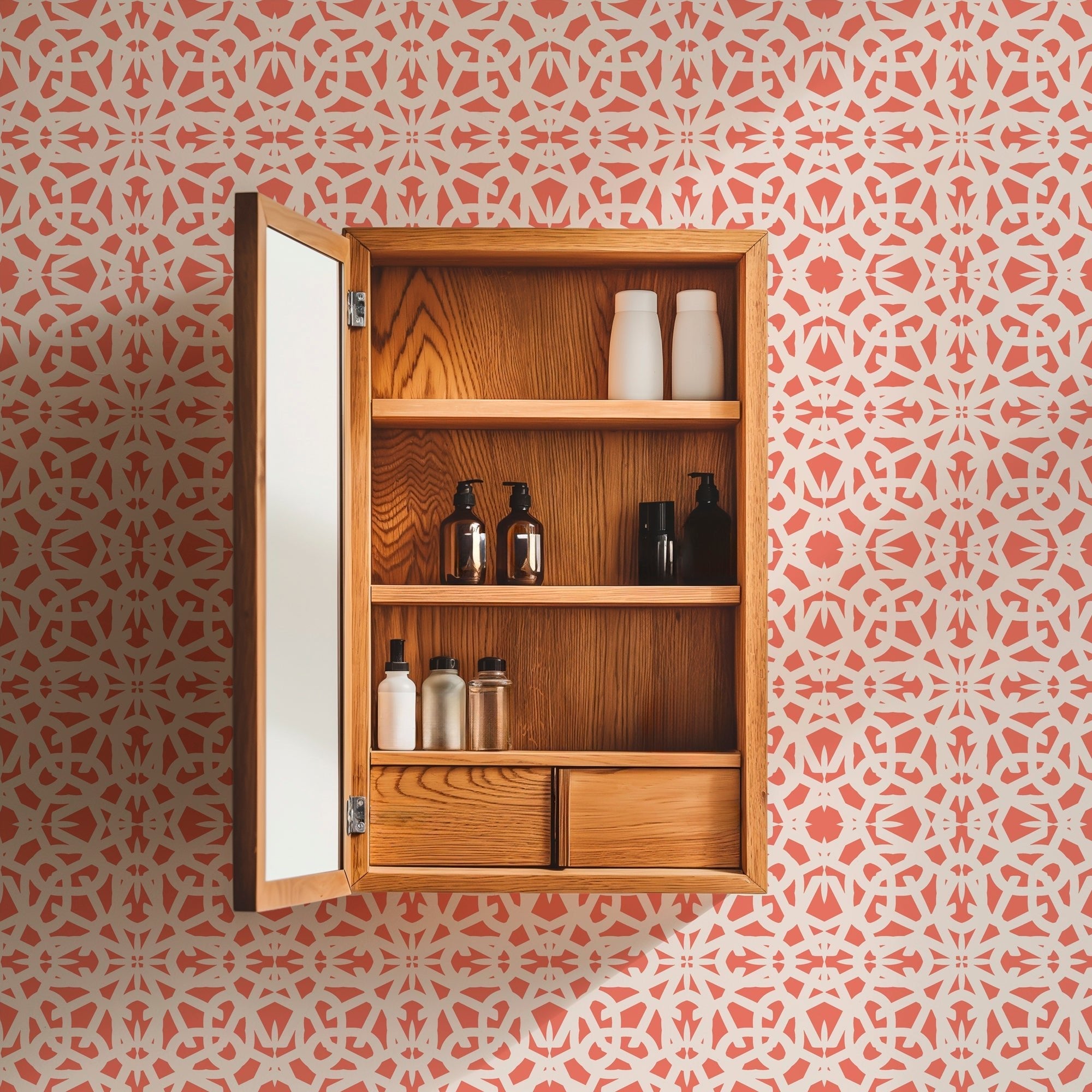 coral wallpaper with a lace pattern on a wall behind an oak medicine cabinet