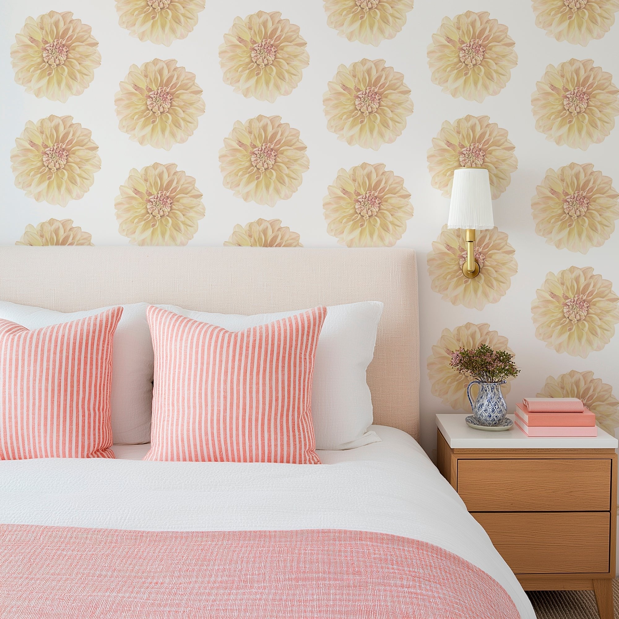 large dahlia floral wallpaper on a bedroom wall behind a bed with pink linens