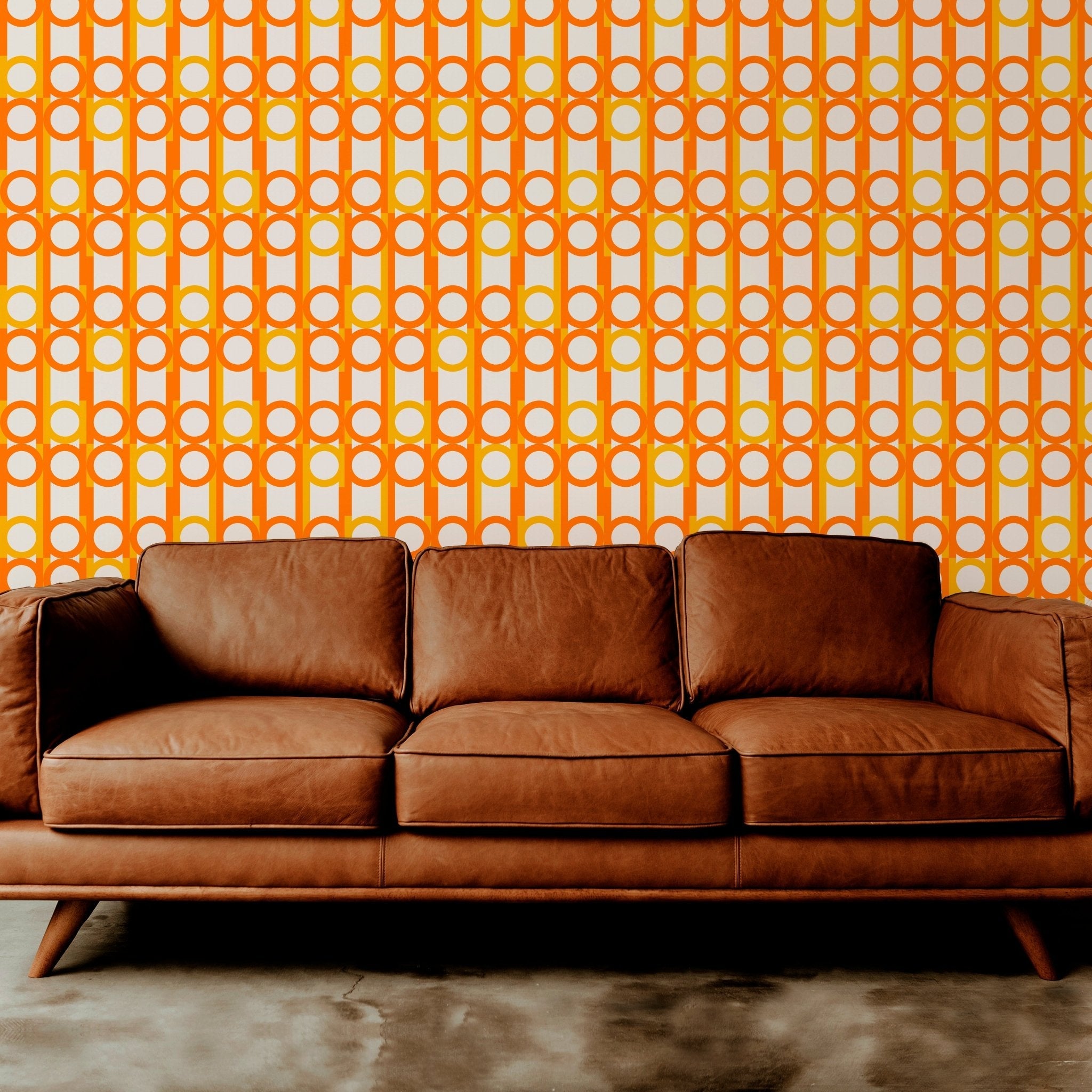 peas and cues orange wallpaper on a wall behind a brown leather couch