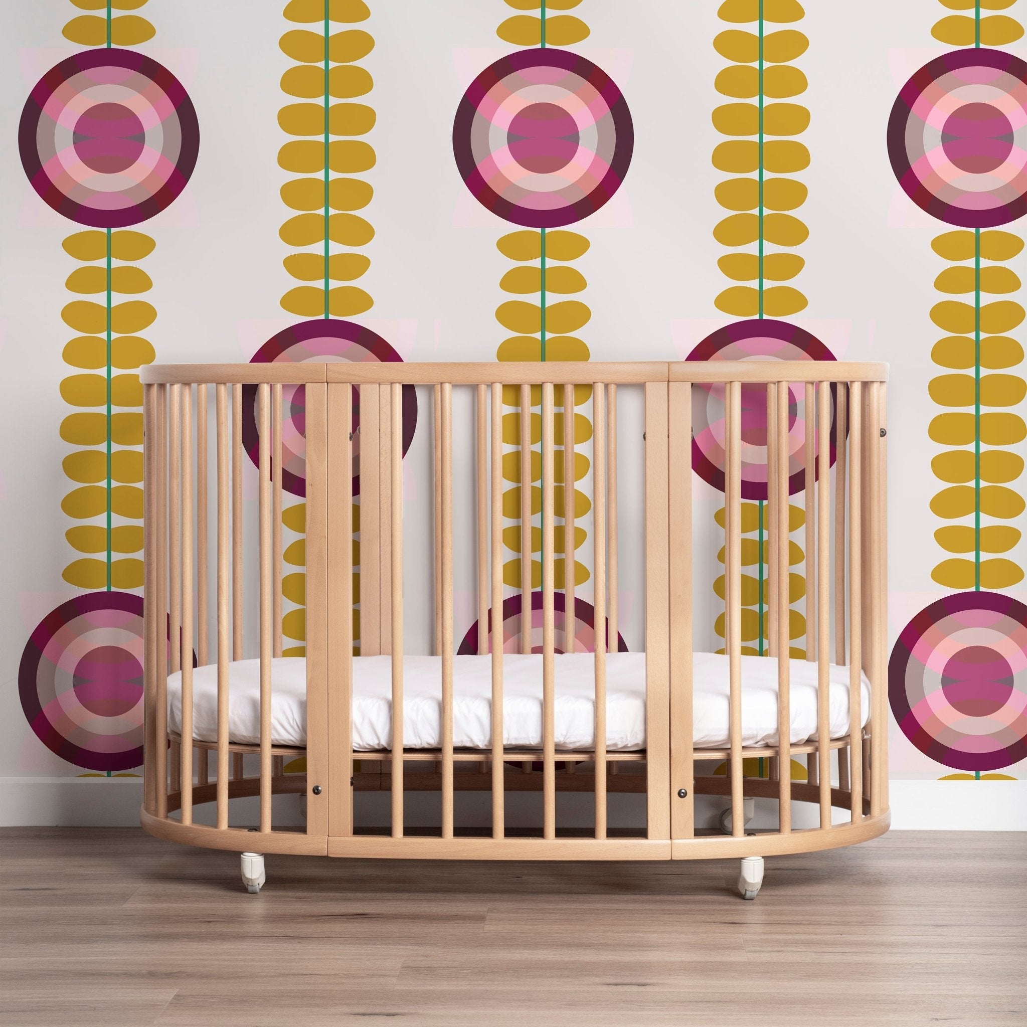 Scandinavian floral wallpaper shown in a nursery behind a modern wood crib