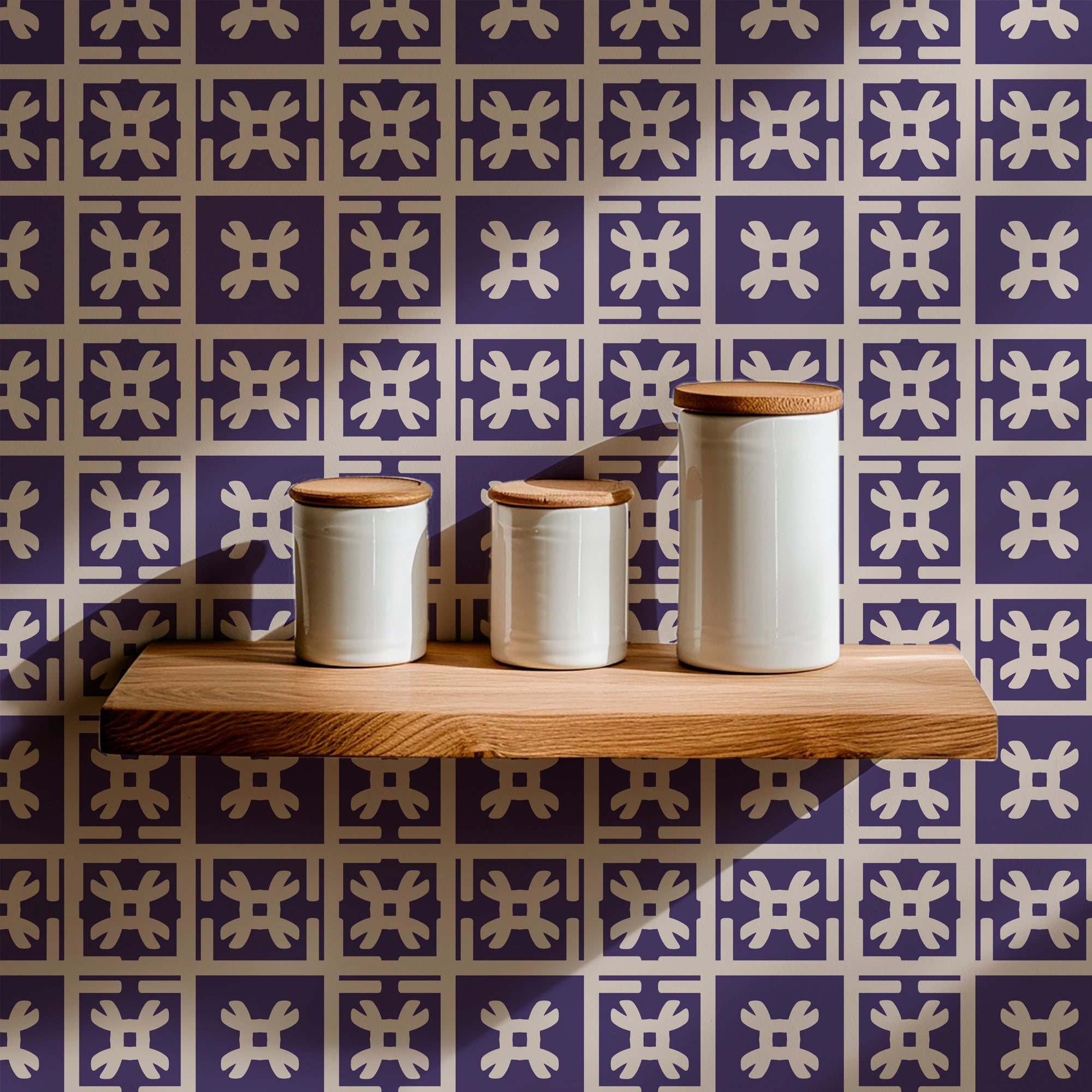 purple and cream Japanese motif wallpaper in a kitchen behind a wood shelf holding cream colored containers