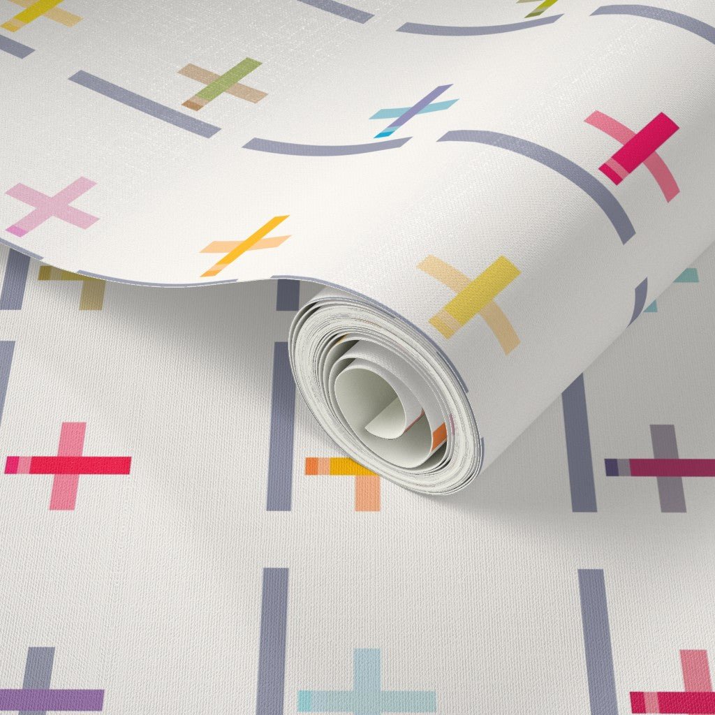 Roll of wallpaper with colorful plus signs on a white background