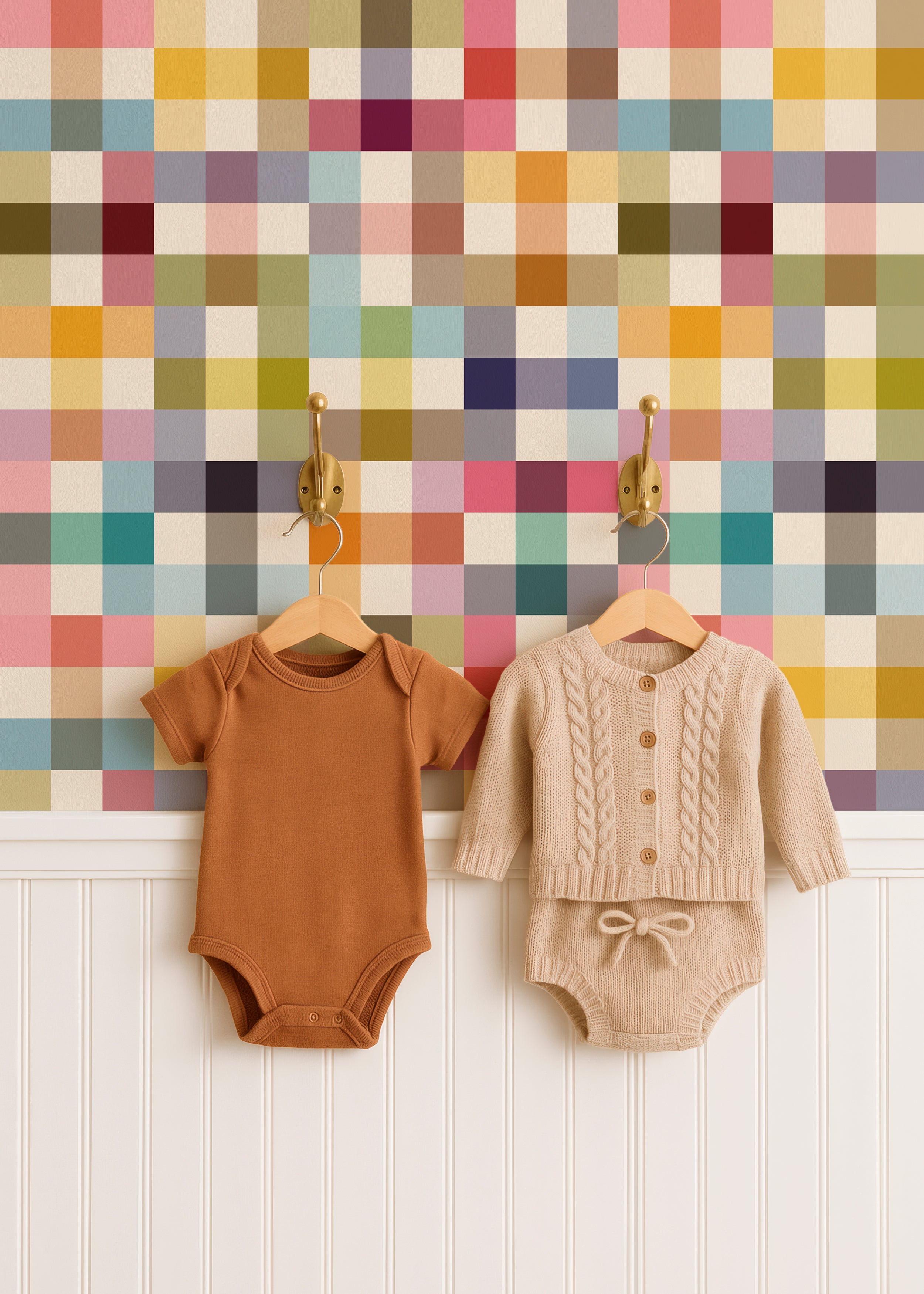 colorful grid nursery wallpaper on a wall behind some hanging pieces of baby clothing