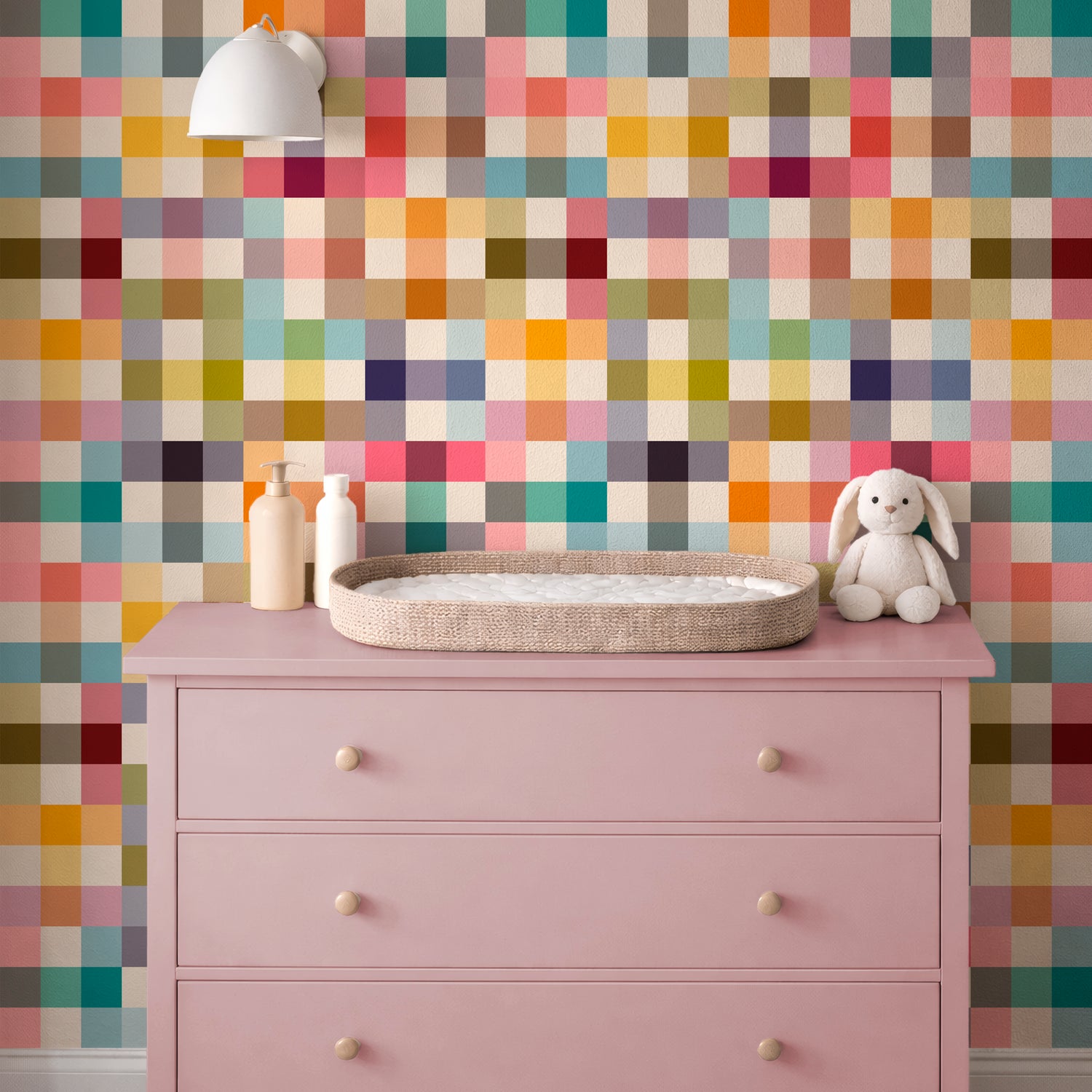 Jellybean colorful grid wallpaper in a nursery with a pink dresser and changing area