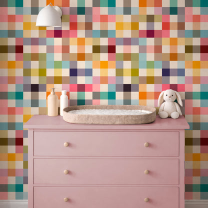 Jellybean colorful grid wallpaper in a nursery with a pink dresser and changing area