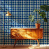 Blueberry retro dot wallpaper shown in a living room with a wood credenza and brass lamp