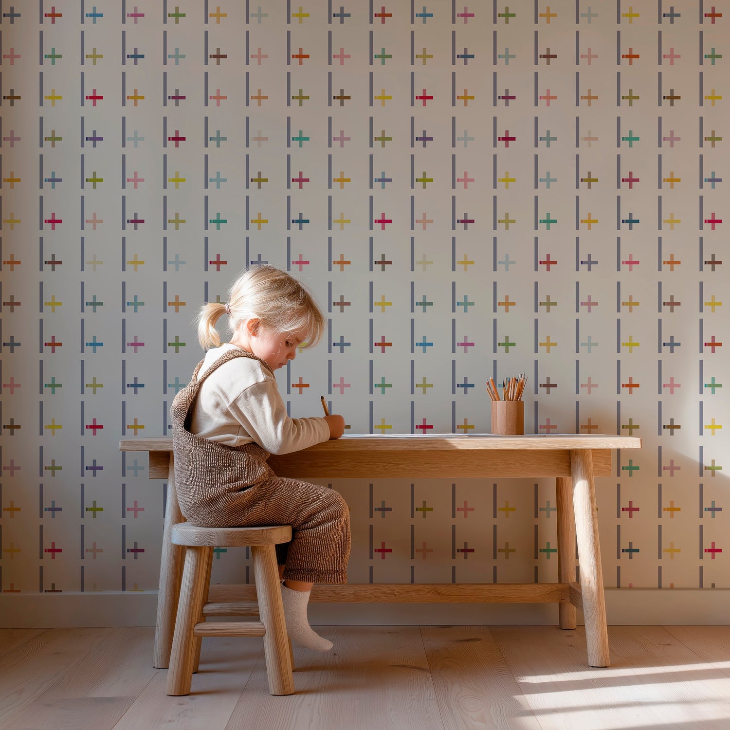 child sitting at a small wooden desk with Pluz wallpaper on the wall
