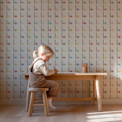 child sitting at a small wooden desk with Pluz wallpaper on the wall